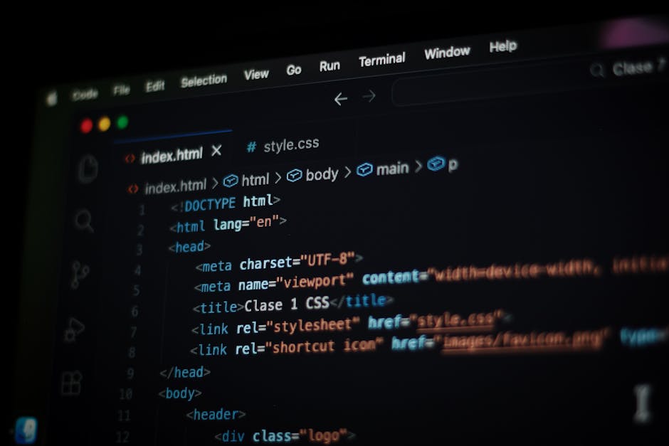 A close-up photograph of a computer screen displaying a code editor with HTML and CSS code. The visible code includes tags such as <html>, <head>, <title>, and <link>, with syntax highlighted in vario